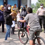 Ketua TP PKK Kota Kediri Ferry Silviana Abu Bakar saat berbincang dengan Saiful yang langsung mencoba naik sepedanya. foto: ist.