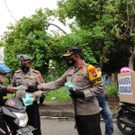 Kombes Pol. Sumardji saat membagikan masker ke pengendara. (foto: ist)