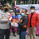 Wakapolres Kediri Kota Kompol Teguh Santoso secara simbolis menyerahkan bantuan kepada mahasiswa untuk selanjutnya disalurkan kepada warga, Rabu (4/8). (foto: ist)