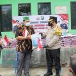 Kapolres Kediri Kota AKBP Wahyudi menyerahkan secara simbolis paket bantuan bersama replika Bendera Merah Putih kepada Ketua HMI Cabang Kota Kediri Faizal Kurniawan. foto: ist.