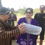 Pj Wali Kota Zanariah bersama Koordinator WWI Regional Kediri, Bima Nuryawan, saat akan menebar benih ikan di Sungai Brantas. Foto: Ist. 