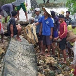 Warga saat gotong royong lakukan perbaikan jalan cor akses menuju Dusun Gili Barat-Desa Dekatagung, Kecamatan Sangkapura yang terputus. Foto:ist.