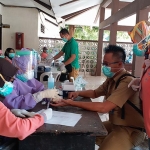 Ainul Yaqin, S.E., M.M., Sekcam Kamal didampingi Hj. Nur Khotibah, Kapus Kamal saat melakukan rapid test di Kantor Kecamatan Kamal yang dilaksanakan Tim Covid-19 Hunter Jatim bersama Dinkes Bangkalan, Senin (8/6).