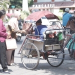 Staf Bagian Protokol dan Komunikasi Pimpinan Pemkot Kediri yang berkolaborasi dengan PWI dan IJTI saat membagikan makanan kepada tukang becak. foto: ist.