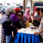 Warga antre di salah satu tenan beras pasar sembako murah di halaman kantor Pemkab Gresik. foto: SYUHUD/ BANGSAONLINE