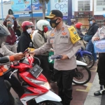 Kapolres Kediri Kota, AKBP Miko Indrayana saat membagikan masker kepada pengguna jalan di pemberhentian lampu merah Alun-Alun Kota Kediri, Selasa (22/9). (foto: ist.)