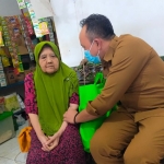 Camat Gresik, Agung Endro Dwi Setyo Utomo, saat menyantuni janda veteran. Foto: SYUHUD/ BANGSAONLINE