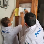 Petugas saat menempel stiker di rumah warga penerima manfaat. 