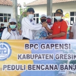 Ketua DPC Gapensi Gresik, Khoirul Aman Makhrudy menyerahkan bantuan kepada korban banjir secara simbolis. foto: ist.