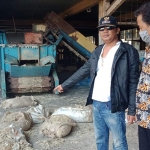 Kades Gempol Chamdi saat menunjukkan sumber limbah dan bekas bulu ayam.