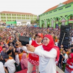 Khofifah Indar Parawansa dan Gus Barra foto bersama dengan background ribuan santri Pondok Pesantren Amanatul Ummah Pacet Mojokerto, Ahad (18/8/2024) sore. Foto: istimewa