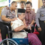 Kabid Humas Iwhan Tri Cahyono bersama Kapolres Kediri AKBP Erick Hermawan saat membantu salah satu penerima baksos. foto: Arif Kurniawan/ BANGSAONLINE