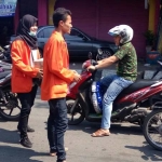 Mahasiwa yang tergabung dalam komunitas MGN saat penggalangan dana di perempatan Kebomas. foto: ist