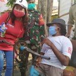 Anggota PSMTI saat membagikan paket sembako ke salah satu warga difabel.