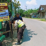 Petugas Polsek Senori saat memasang salah satu banner imbauan mencoblos.