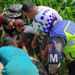 Petugas dibantu warga saat mengevakuasi korban yang tewas tertabrak KA Dhoho di Kediri. Foto: Ist