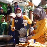 Wali Kota Batu Dewanti Rumpoko (pegang sutil) ikut menggoreng tempe saat menghadiri Festival Beji Kampung Tempe.