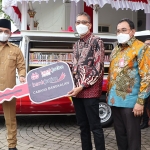 Direktur Utama Bank Jatim, Busrul Iman, saat memberikan bantuan CSR kepada Bupati Bangkalan, R Abdul Latif Amin Imron, secara simbolis.