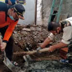 Anggota Banser bergotong royong melaksanakan bedah rumah keluarga Makki, korban kebakaran di kawasan Kecamatan Simokerto, Surabaya. foto: ist.