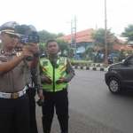 Kompol Wahyu Endrajaya saat mencoba speed gun.