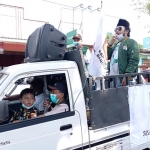 Hotib Marzuki (berdiri sambil merokok) Wakil Ketua DPRD Bangkalan sekaligus Pengurus Ansor Kecamatan Kamal saat sosialisasi prokes sambil bagi-bagi masker gratis.