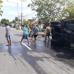 Warga membersihkan muatan HCL yang tumpah ke jalan.