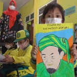 Salah satu murid TK Al-Hidayah menunjukkan gambar KH. Hasyim Asy