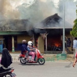 Warga saat berupaya memadamkan api dengan alat seadanya.