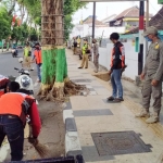 Para pemuda yang terjaring razia sedang dihukum bersih-bersih.