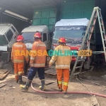 Petugas Damkar Gresik saat melakukan pemadaman kebakaran di bengkel PT Yani Putra. Foto: SYUHUD/BANGSAONLINE
