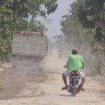 TEBAL – Debu tebal beterbangan saat hilir mudik truk mengangkut material proyek pembuatan jalan akses lokasi galian C, di Desa Karangmalang Kecamatan Kasreman Ngawi, Kamis (10/9). Foto: agus honk/BANGSAONLINE