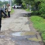 Warga Desa Karang Tanjung, :Syaipul menunjukkan  jalan berlubang akibat pipa PDAM Sidoarjo, kemarin. foto : khumaidi/BangsaOnline