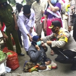 Salah seorang warga di pinggir jalan menerima pembagian masker. 