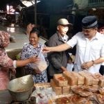 Gus Syaf memborong kue di lapak milik Pak Wagino. foto: BANGSAONLINE
