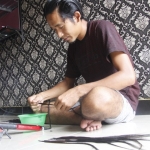 Wahyu sedang sibuk merangkai sisa potongan rambut.