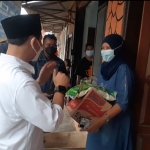 Gus Barra menyerahkan bantuan sembako kepada salah satu pedagang.