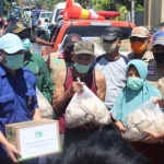 Wabup Mujib Imron (paling kanan) saat menyerahkan bantuan bagi warga terdampak banjir.