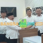 Ketua DPC PKB Kabupaten Madiun, Muhtarom, saat menyerahkan berkas laporan ke polisi. Foto: HENDRO UTOMO/BANGSAONLINE