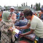 Bupati Jombang, Mundjidah Wahab, saat membagikan bantuan untuk tukang becak.