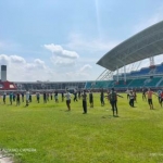 Orang-orang yang dikarantina di Jember Sport Garden (JSG) Kabupaten Jember diajak olahraga dan berjemur di terik matahari. foto: ist/ bangsaonline