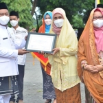 Bupati Gresik, Fandi Akhmad Yani, didampingi wakilnya saat menyerahkan penghargaan. Foto: SYUHUD/BANGSAONLINE.