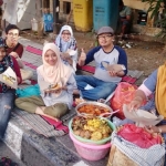 Sejumlah warga sedang asyik menikmati nasi boranan yang dijajakan seorang penjual makanan khas Lamongan ini.