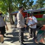 Kapolres Jombang, AKBP Agung Setyo Nugroho saat membagikan paket sembako kepada salah satu tukang becak. foto: AAN AMRULLOH/ BANGSAONLINE