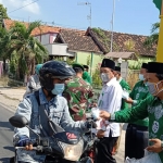 Kepala KUA Paciran, Ach. Suyitno dan penyuluh agama turun jalan bagi-bagi masker dan vitamin.