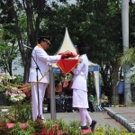 Bupati Sambari menyerahkan bendera merah putih kepada pasukan Paskibraka untuk dikibarkan. foto: SYUHUD/ BANGSAONLINE