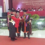 Rektor UISI, Prof. Dr. Ing. Herman Sasongko memberikan penghargaan kepada wisudawan berprestasi.