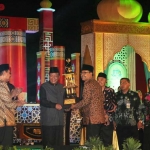 Bupati Sambari saat menerima trofi dari Wagub Jatim Saifullah Yusuf sebagai pemenang MTQ XXVII 2017. foto: SYUHUD/ BANGSAONLINE