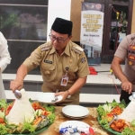 Bupati Blitar Rijanto dan Kapolres Blitar AKBP Anissullah M Ridha memotong tumpeng dalam acara tasyakuran.