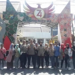 Kapolres Pamekasan beserta jajaran sedang foto di depan gapura Mapolres.