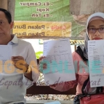 Erna Hari Purwanti didampingi suaminya saat menunjukkan bukti pengaduan ke polisi dan rekening koran BRI miliknya. Foto: MUJI HARJITA/ BANGSAONLINE